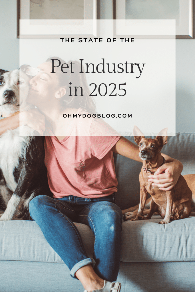 The image features a woman sitting in between her two dogs on a gray sofa. The woman is white with a pink t-shirt and scuffed blue jeans. She is hugging the dog to her right, a white and black dog that looks like a border collies mix. Her arm is around the dog to her left which looks like a brown Chihuahua mix with a white face. The text overlay reads: The State of the Pet Industry in 2025. 